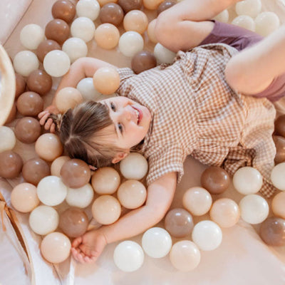 Elle joue avec ses balle piscine a balle hor de la piscine pour un jeux créatif et immaginatif