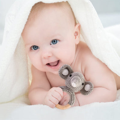 Bébé exprime sa joie en serrant son hochet entre les doigts