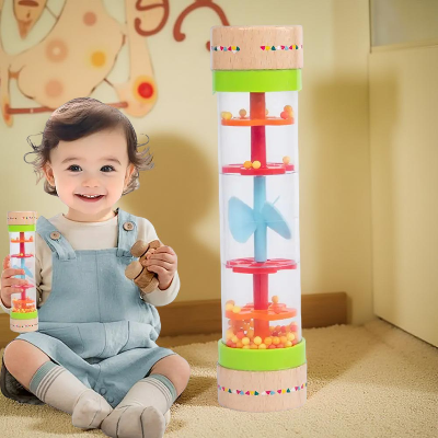 Un visable bébé heureux stimulé par le son du baton de pluie.