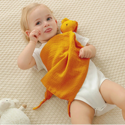Un bébé joyeux et taquin avec son doudou lapin.