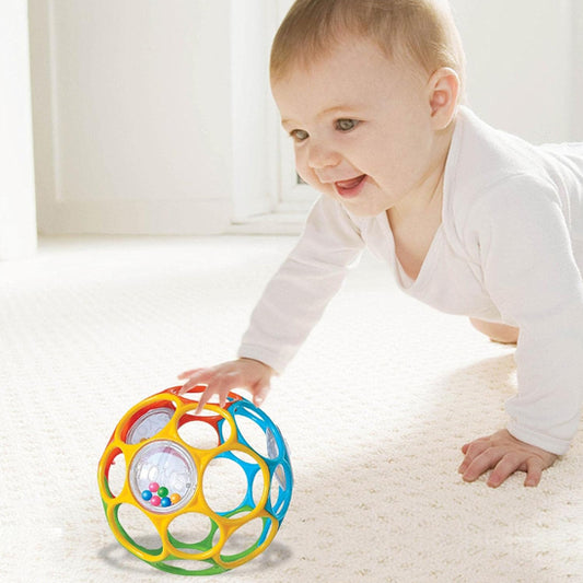 Bébé apprend a saisir son hochet bebe à trous 