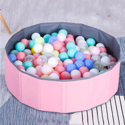Piscine a balle pour bebe rose avec des balles macaron